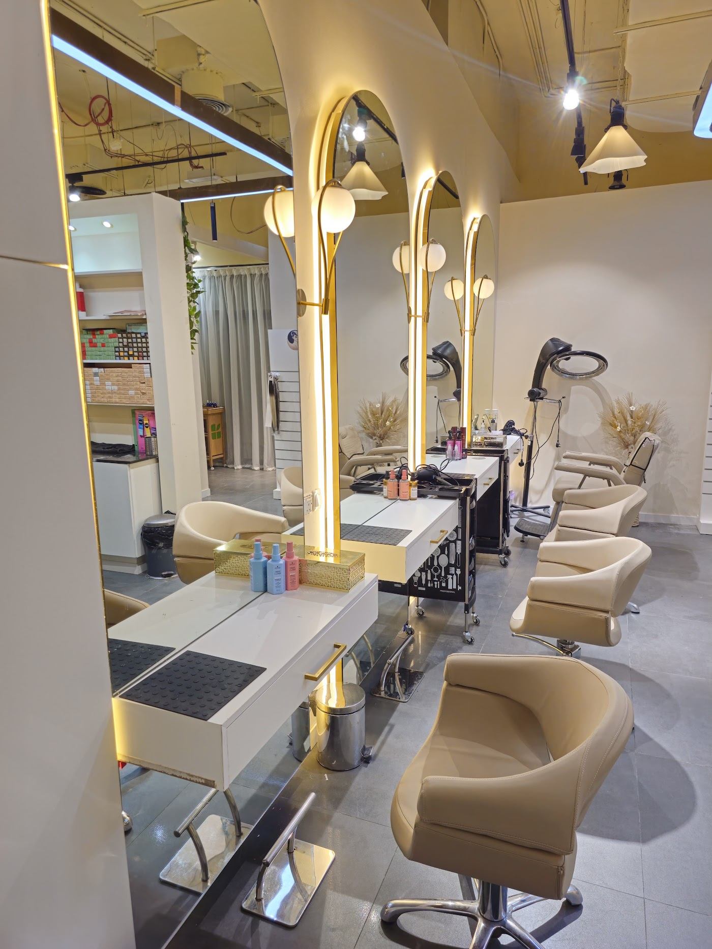 Lux Atila salon interior with arched gold-lit mirrors and cream styling chairs